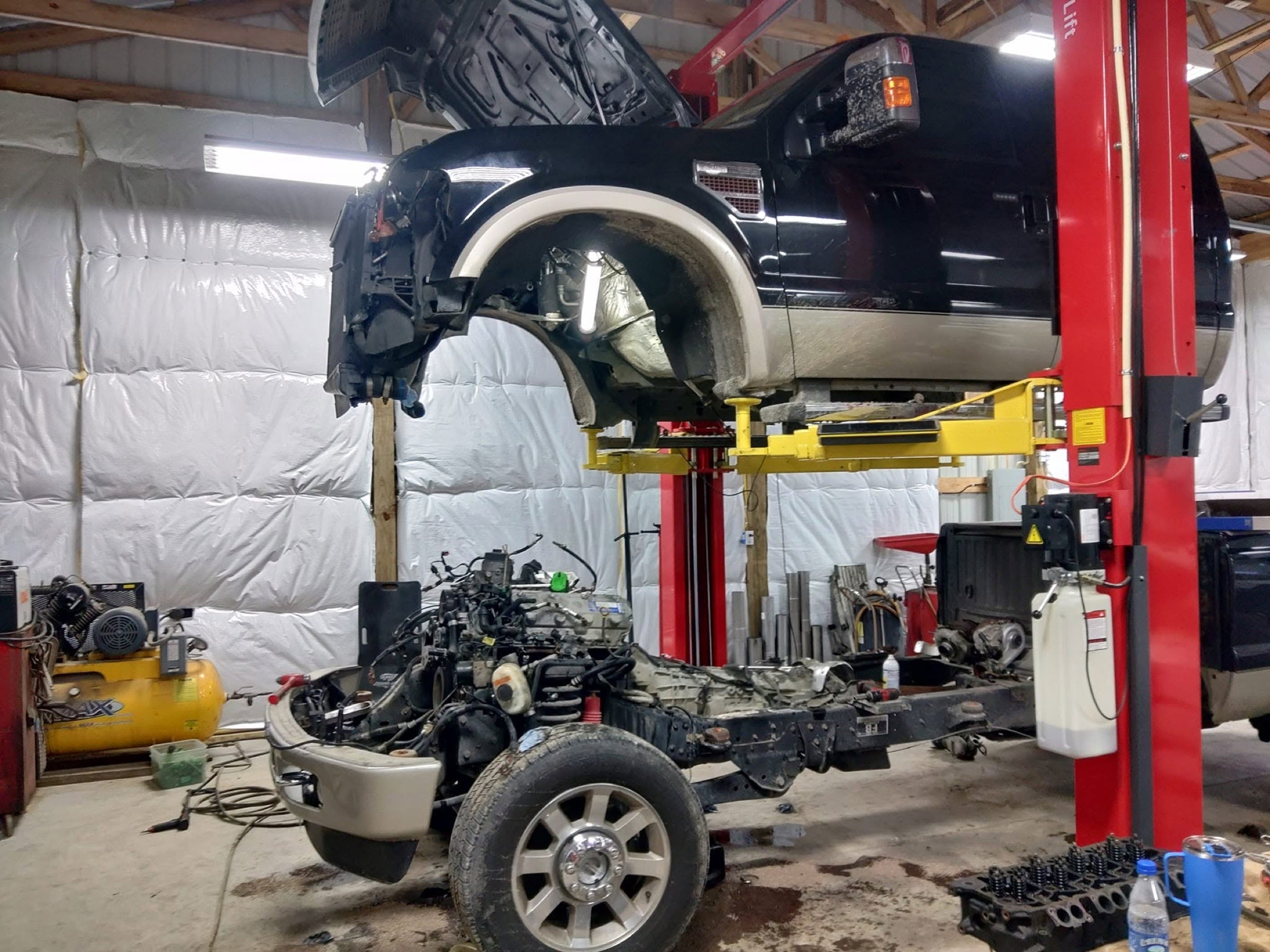 Ford diesel truck undergoing major service on a lift at J&J Performance
